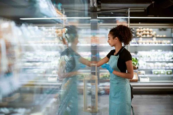 person reaching into commercial refrigerator